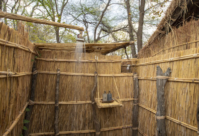 Open-fronted rustic chalet bedroom offering uninterrupted river views and true wilderness immersion at Mwaleshi Camp