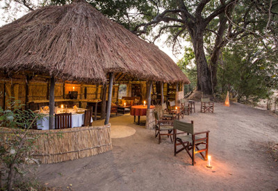 Cozy outdoor firepit and sitting area set on the riverbank for evening relaxation at Mwaleshi Camp