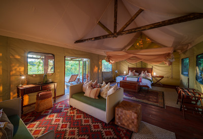 Classic luxury canvas tented suite interior featuring a king bed and private viewing deck at Zungulila Bushcamp