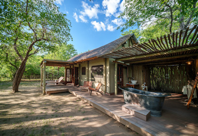 Zungulila Bushcamp dining deck under a thatch canopy serving high-end safari cuisine to guests