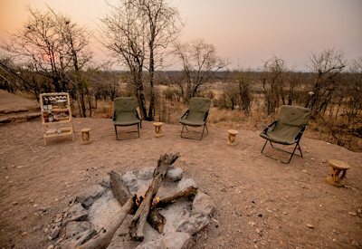 Camp Chitubu open-air firepit lounge bar night escort nocturnal wildlife Hwange Zimbabwe