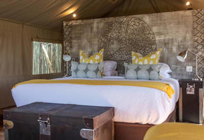 Deteema Springs Camp comfortable queen bed suite animals past window Hwange Zimbabwe